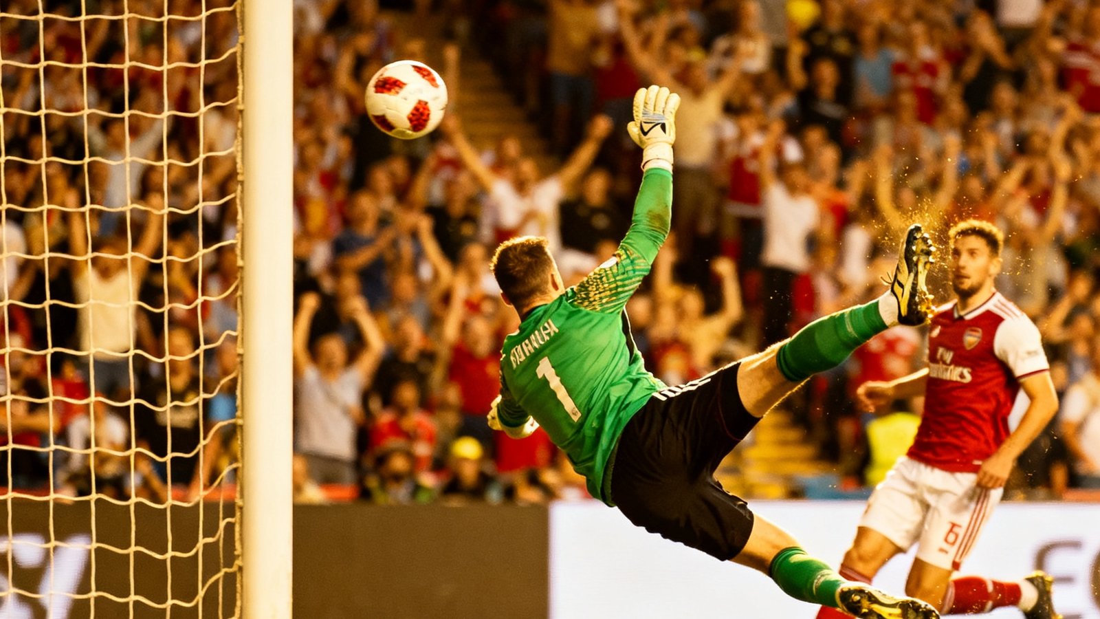 一张比赛集锦的封面截图，画面定格在一记凌空抽射的瞬间，足球刚刚离开球员的脚面，守门员飞身扑救但未能触及，球网微微颤动，背景是欢呼的球迷。